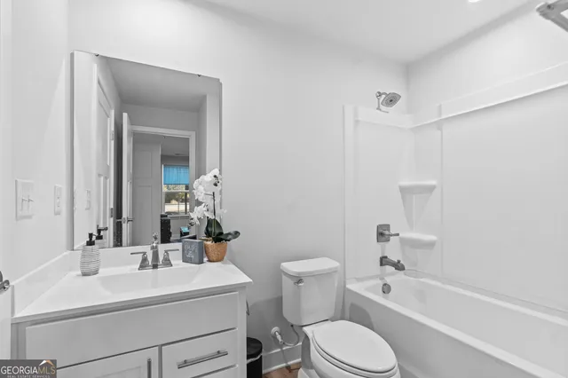 a bathroom with a sink toilet vanity tub and shower