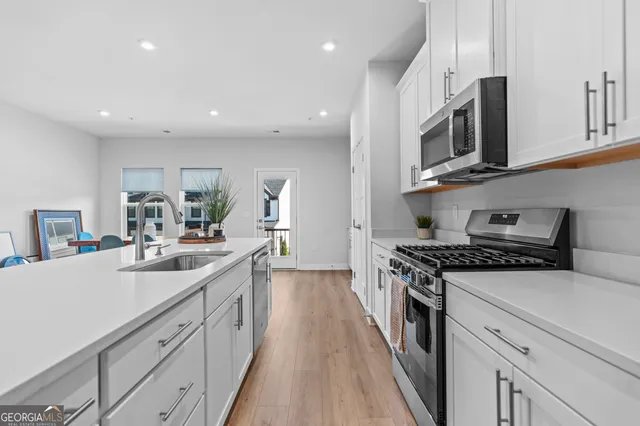 a kitchen with stainless steel appliances sink stove microwave and cabinets