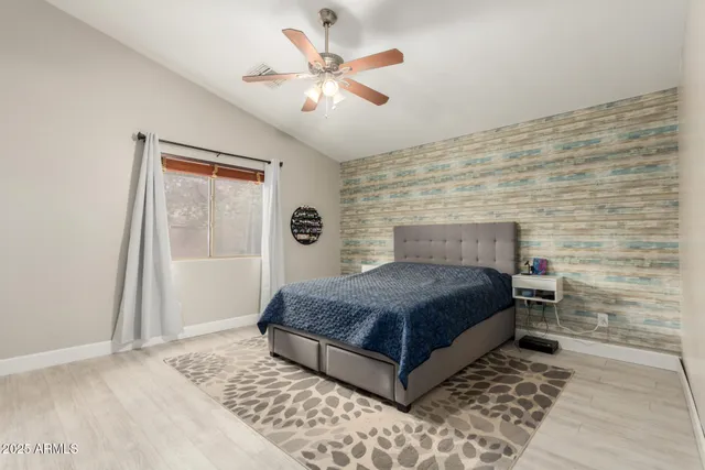 a living room with a bed and a ceiling fan