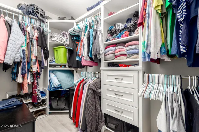 a view of walk in closet with clothes and shoes