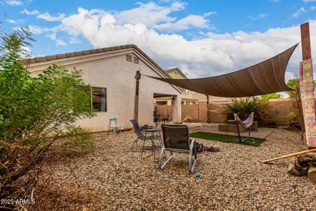 a view of a house with backyard and sitting area