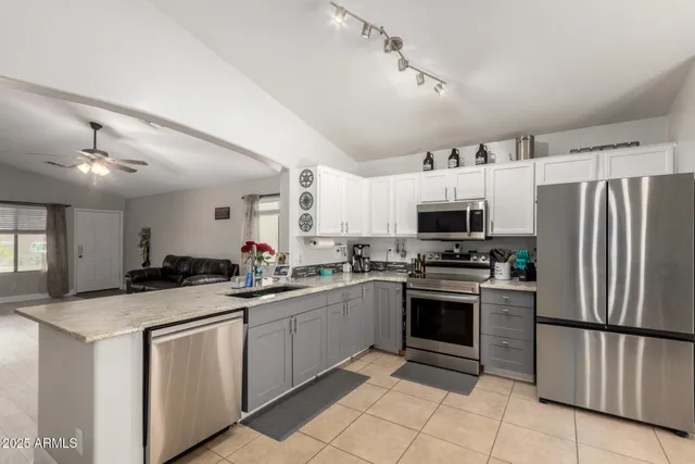 a kitchen with granite countertop a sink stainless steel appliances and cabinets