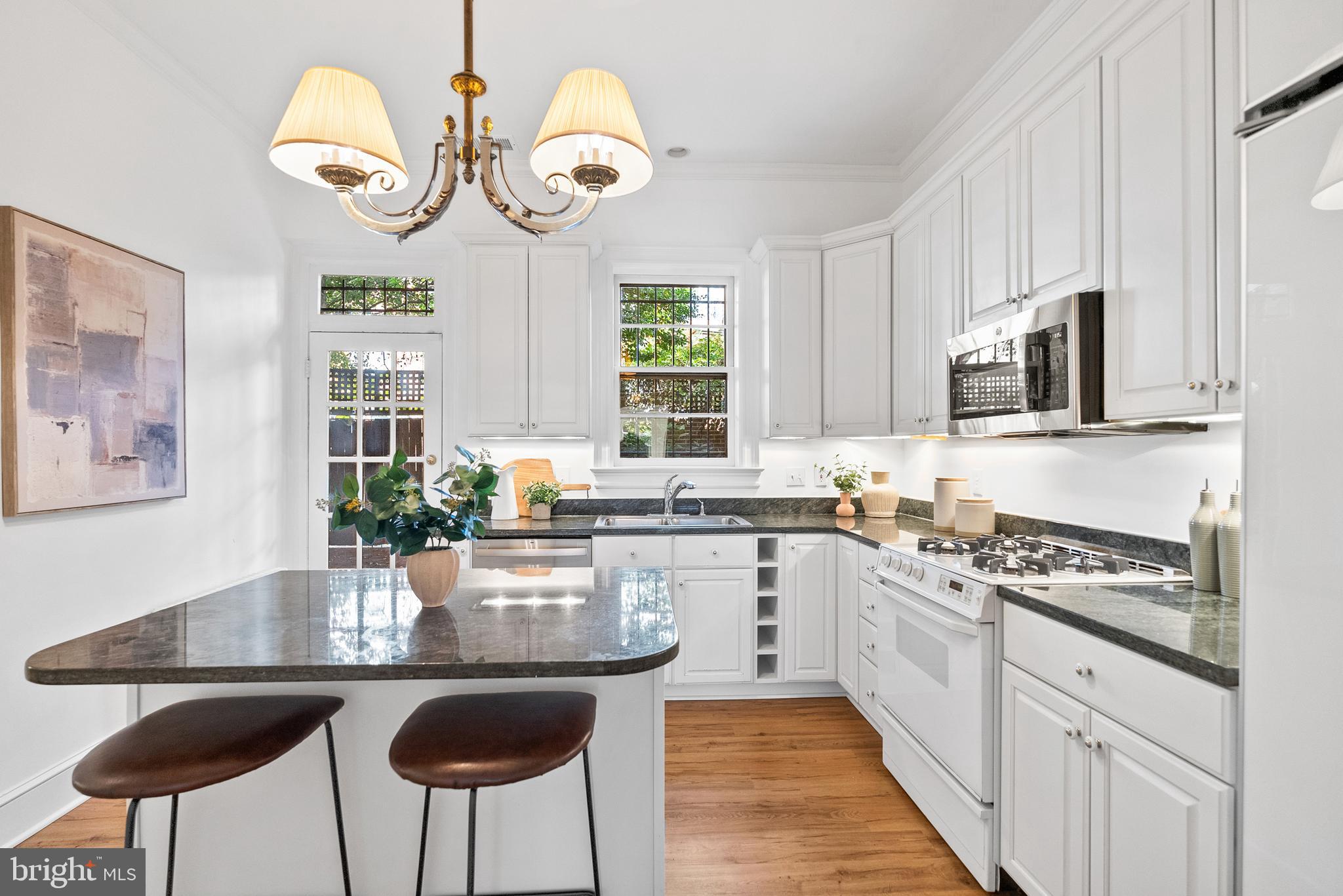 2125 Bancroft Place Northwest Washington, DC 20008 - Photo 16 of 48 a kitchen with stainless steel appliances granite countertop a stove a sink dishwasher and white cabinets with wooden floor