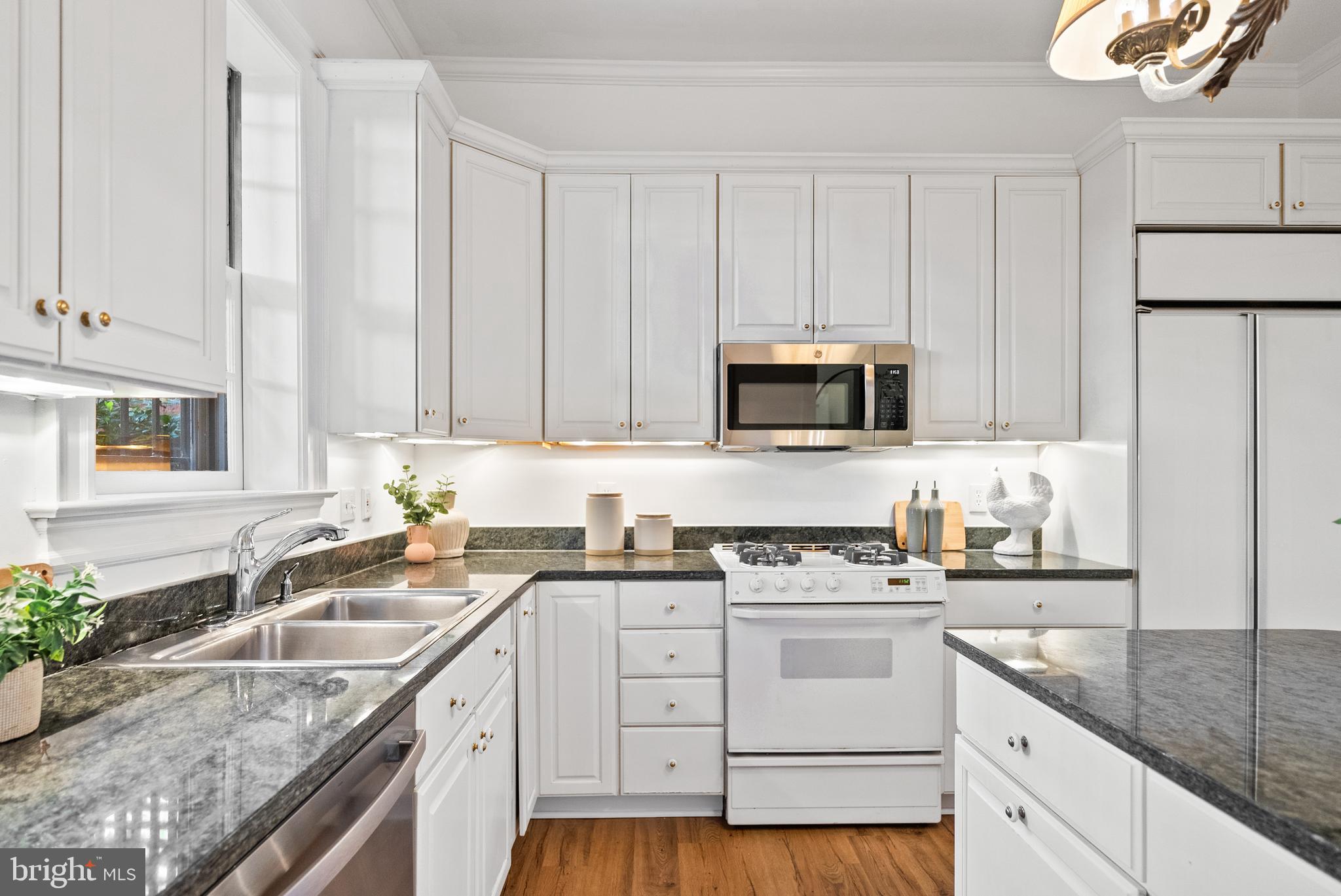 2125 Bancroft Place Northwest Washington, DC 20008 - Photo 17 of 48 a kitchen with granite countertop a sink stainless steel appliances and white cabinets