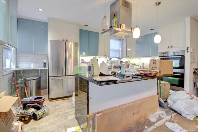 a kitchen with stainless steel appliances granite countertop a refrigerator and a cabinets