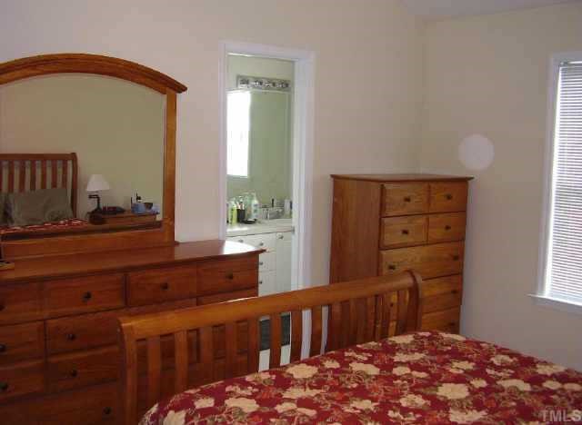 2033 Metacomet Way Raleigh, NC 27604 - Photo 7 of 8 a bedroom with a bed a dresser and a window