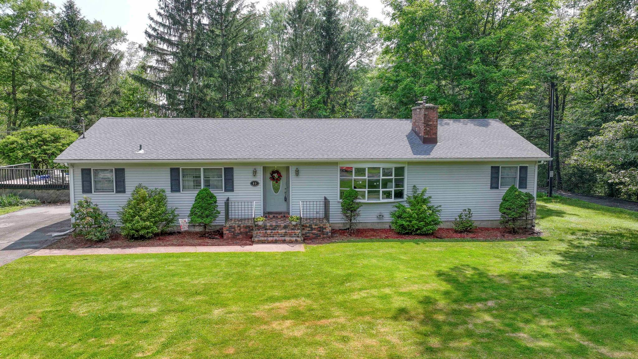Single story home featuring a chimney and roof with shingles