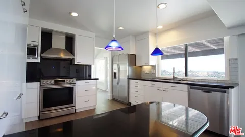 a kitchen with stainless steel appliances granite countertop a stove a sink and a refrigerator