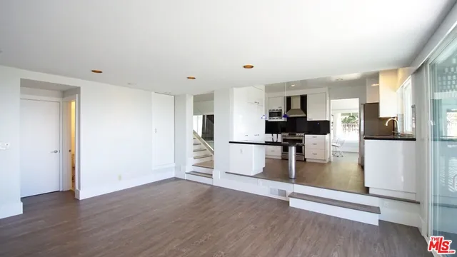 a view of a kitchen with refrigerator stove and wooden floor