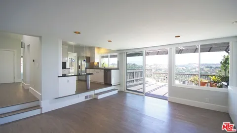 a kitchen with stainless steel appliances wooden floor and window