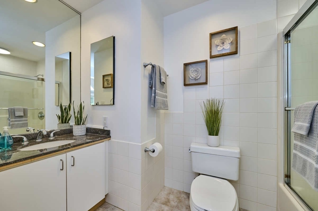 626 Washington Street, Unit 4 Brookline, MA 02446 - Photo 19 of 37 a bathroom with a granite countertop toilet sink and mirror