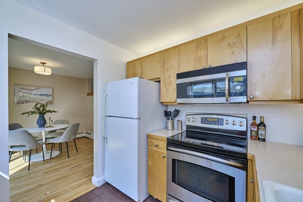626 Washington Street, Unit 4 Brookline, MA 02446 - Photo 32 of 37 a kitchen with a refrigerator and a stove top oven