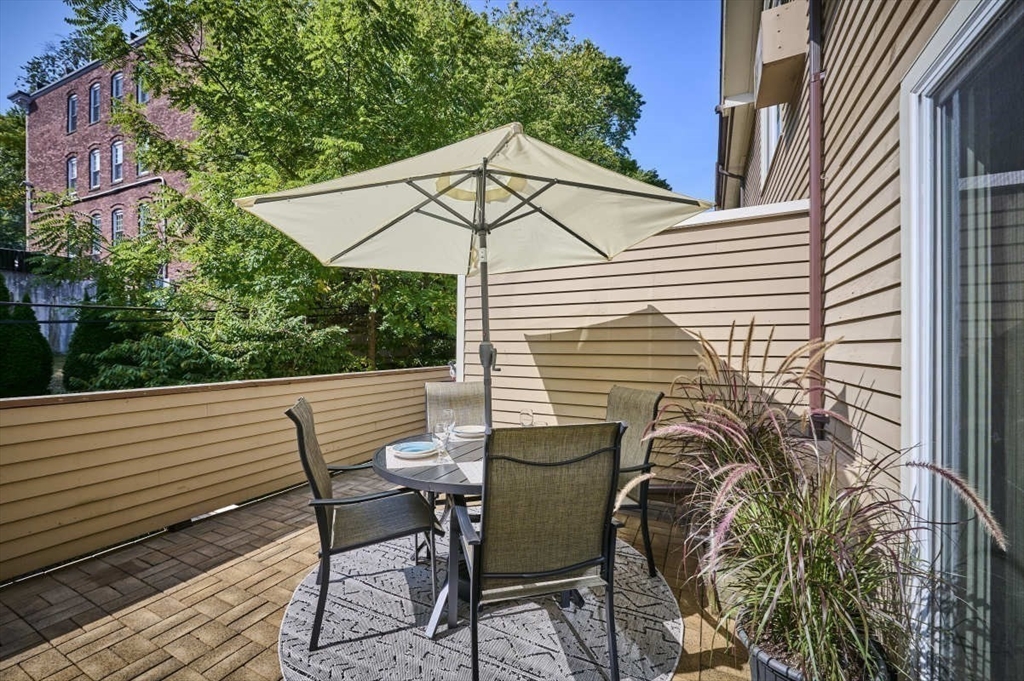 626 Washington Street, Unit 4 Brookline, MA 02446 - Photo 33 of 37 a view of a patio with a table and chairs under an umbrella