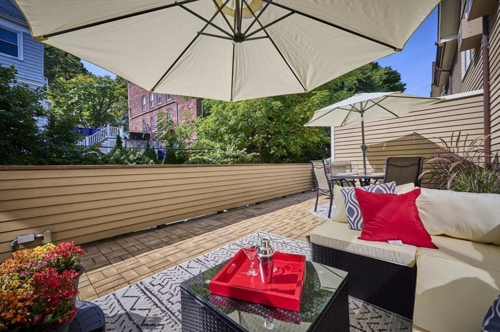 626 Washington Street, Unit 4 Brookline, MA 02446 - Photo 34 of 37 a view of a patio with table and chairs under an umbrella
