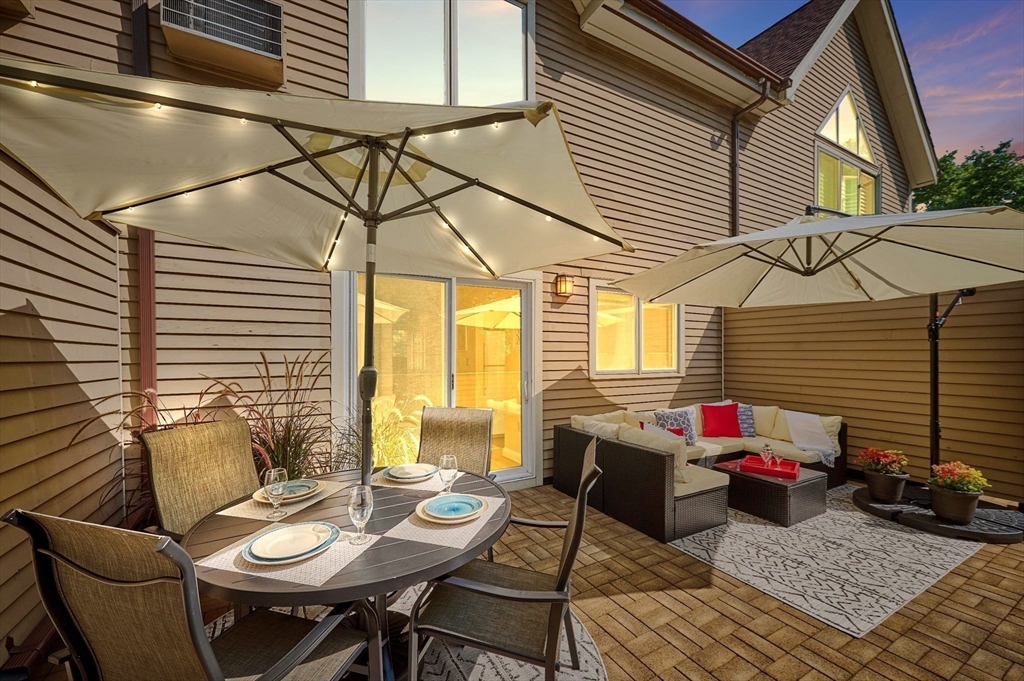 626 Washington Street, Unit 4 Brookline, MA 02446 - Photo 35 of 37 a view of a patio with table and chairs and barbeque grill with floor to ceiling windows