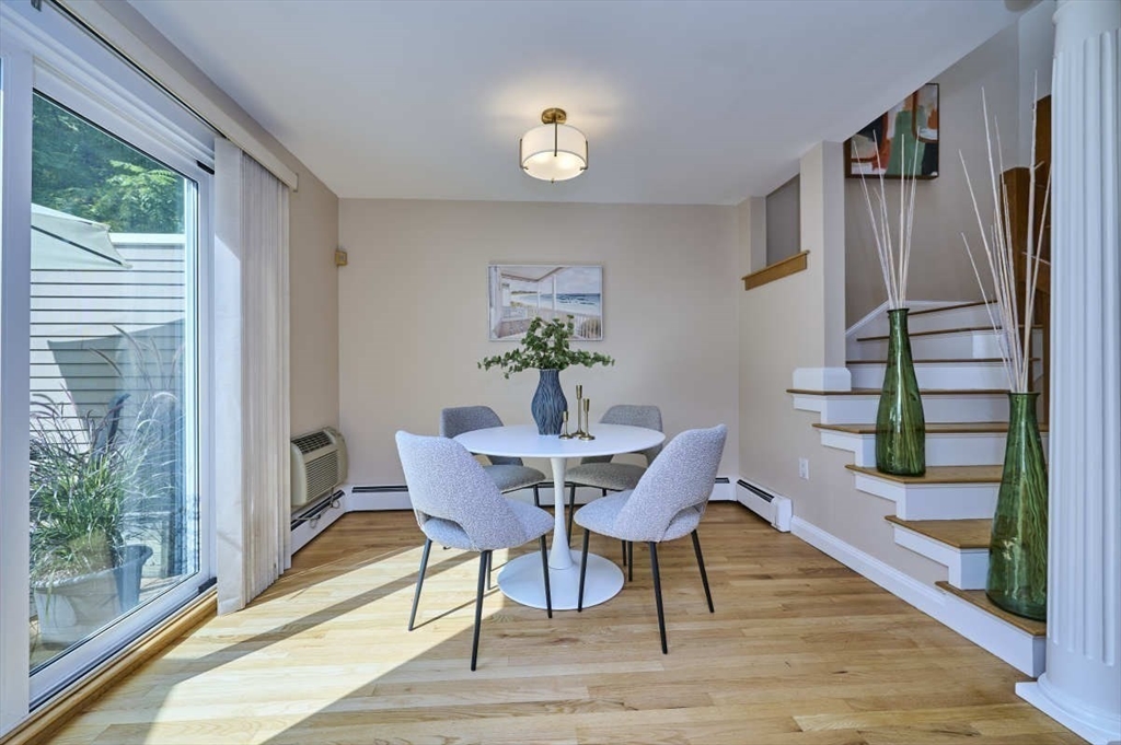 626 Washington Street, Unit 4 Brookline, MA 02446 - Photo 5 of 37 a dining room with furniture a floor to ceiling window and wooden floor
