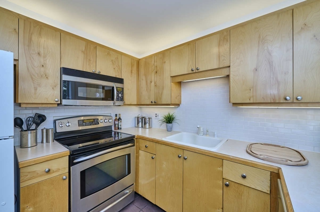 626 Washington Street, Unit 4 Brookline, MA 02446 - Photo 7 of 37 a kitchen with stainless steel appliances a stove microwave and sink