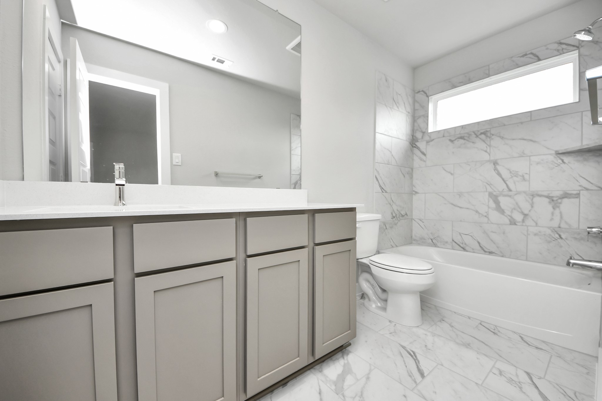 11106 Tulip Rdg Trail Houston, TX 77044 - Photo 32 of 34 Secondary bath features tile flooring, bath/shower combo with tile surround, light stained wood cabinets, beautiful light countertop. Sample photo of completed home with similar floor plan. Actual colors and selections may vary.