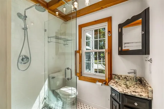 a bathroom with a granite countertop sink toilet and shower