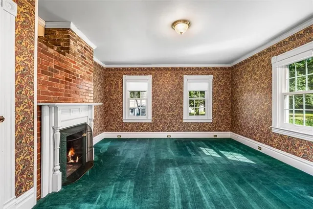 a view of an empty room with window and fire place