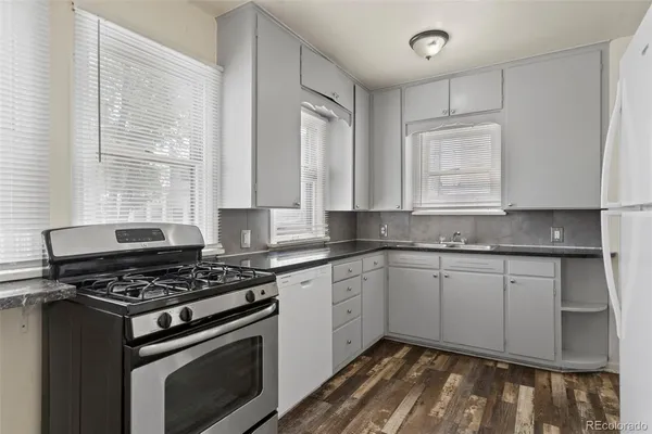 a kitchen with granite countertop cabinets stainless steel appliances and a sink