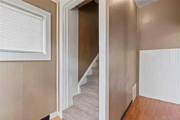 a view of a hallway with wooden floor and entryway