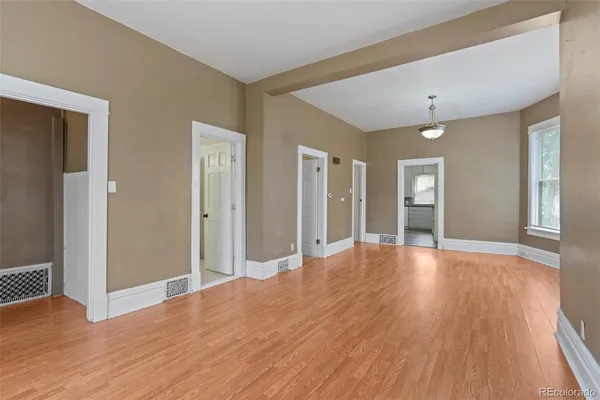 a view of a big room with wooden floor and windows