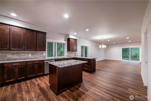 a kitchen with stainless steel appliances granite countertop wooden floors and stove