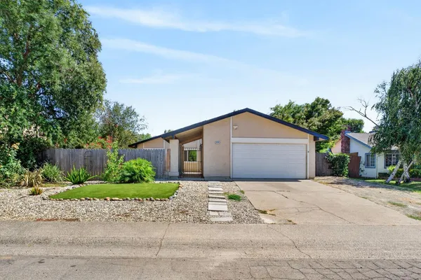 a front view of a house with a yard and potted plants