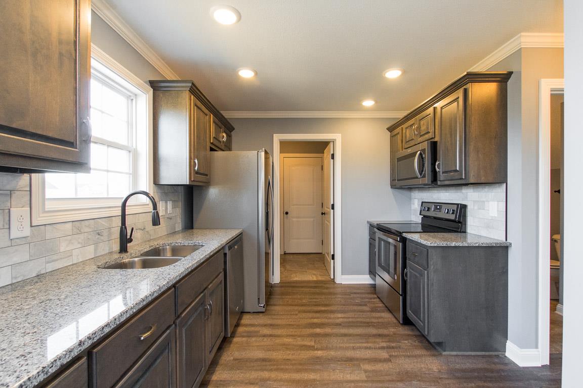 2316 Pea Ridge Road Clarksville, TN 37040 - Photo 12 of 30 a kitchen with stainless steel appliances granite countertop a sink stove and refrigerator