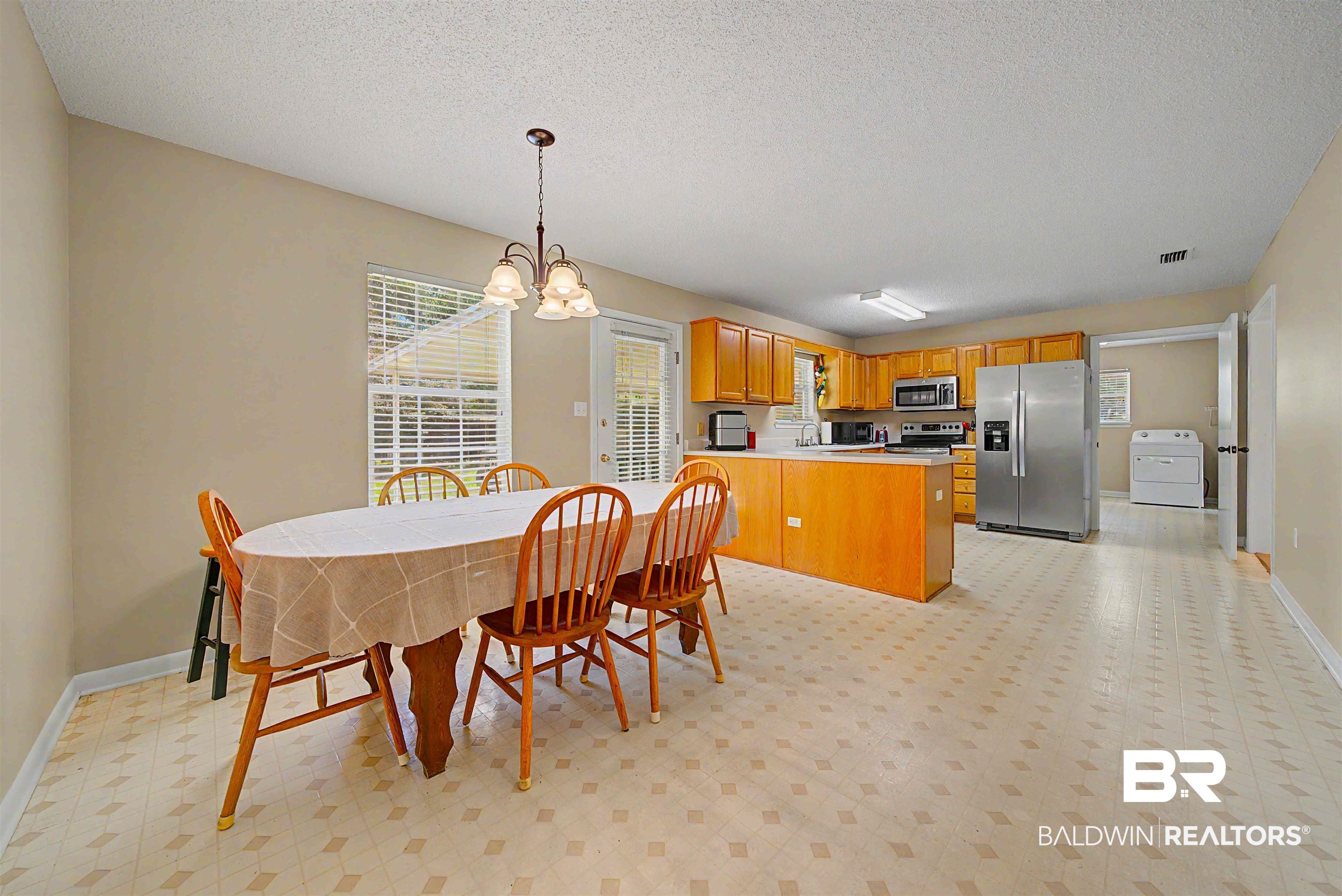 22963 Highway 98 Foley, AL 36535 - Photo 15 of 52 Kitchen and dining area featuring light-toned walls, patterned flooring, and a chandelier-style light fixture