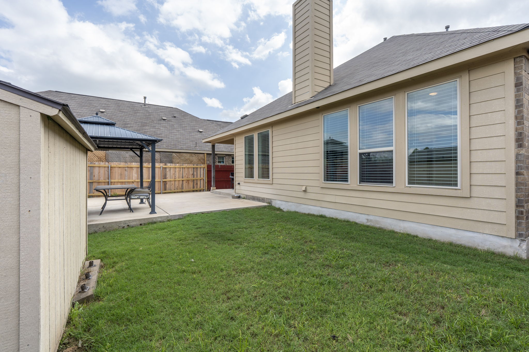 373 Rough Bark Street Buda, TX 78610 - Photo 27 of 39 A well-maintained yard and patio area provide ample outdoor living space.