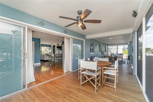 a dining room with wooden floor and a ceiling fan