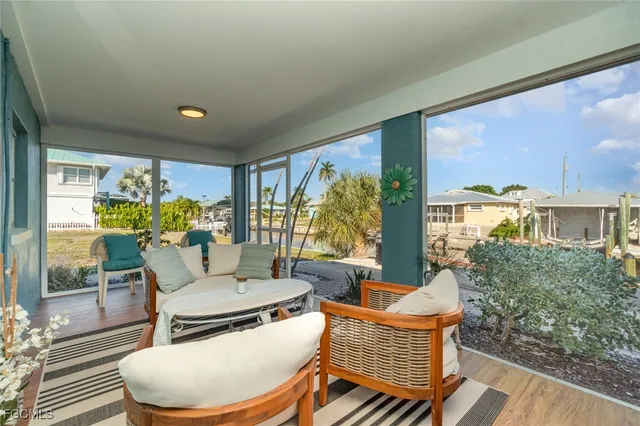 a living room with patio furniture and a potted plant
