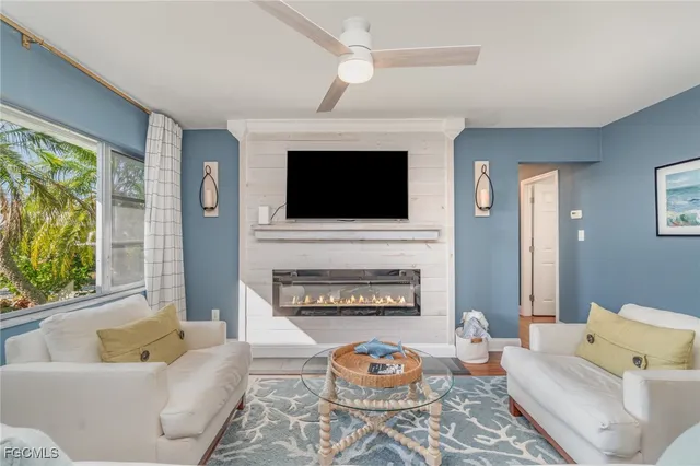 a living room with furniture a fireplace and a flat screen tv