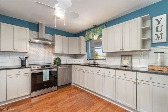 a kitchen with granite countertop white cabinets and white appliances