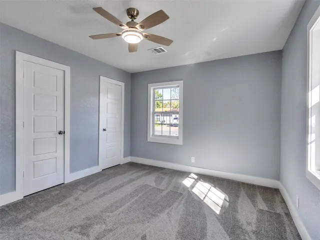 a view of a livingroom with a ceiling fan and window