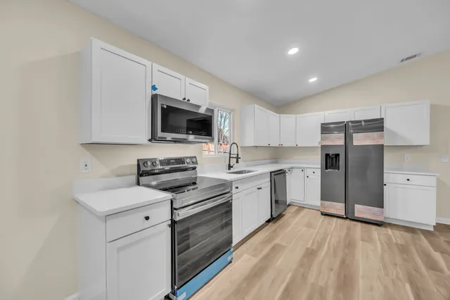 a kitchen with stove cabinets and stainless steel appliances