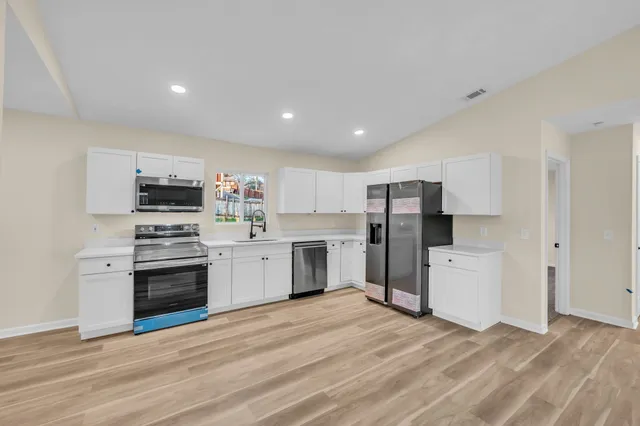 a kitchen with a sink a stove top oven and refrigerator