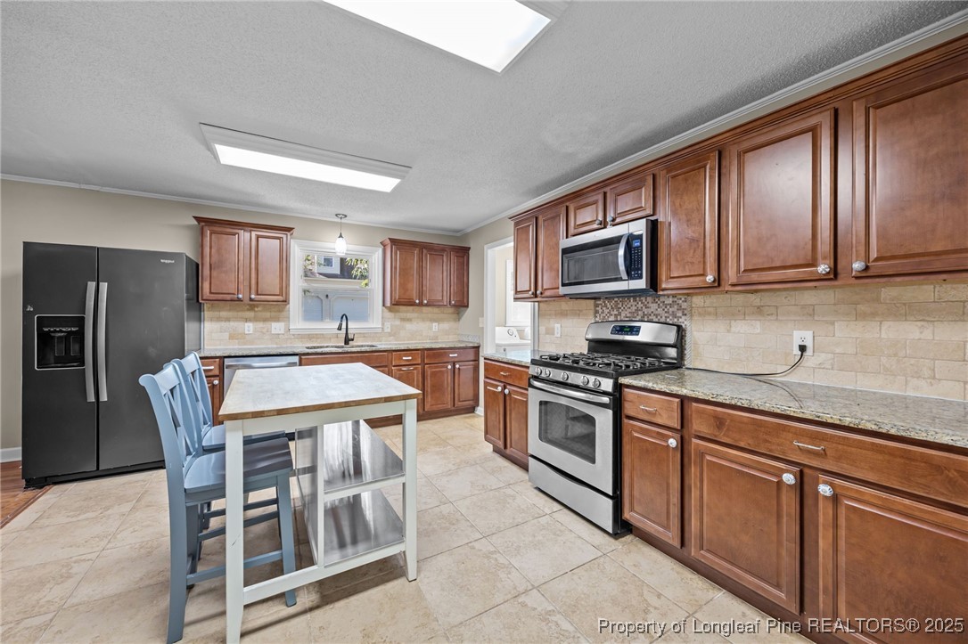 58 Eagle Road Coats, NC 27521 - Photo 24 of 49 a kitchen with stainless steel appliances granite countertop a stove a sink dishwasher a refrigerator and a microwave