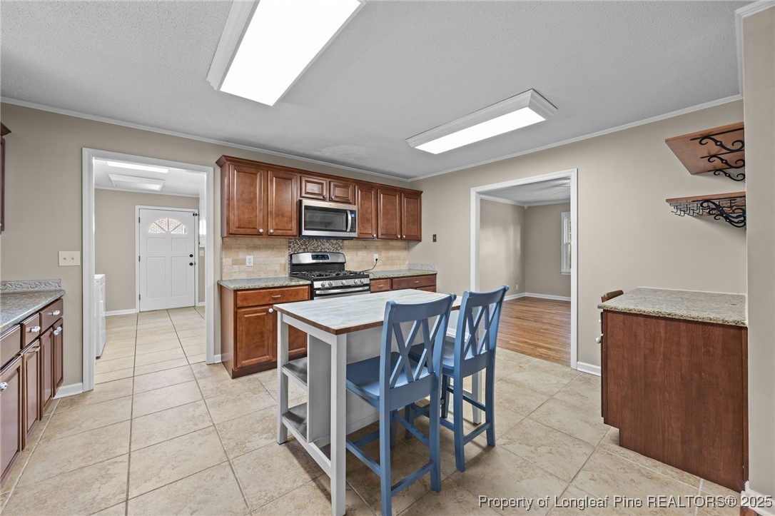 58 Eagle Road Coats, NC 27521 - Photo 26 of 49 a kitchen with stainless steel appliances a stove top oven a sink a dining table and chairs