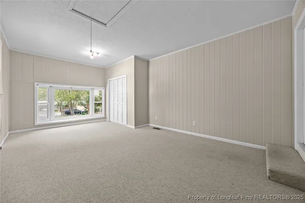 an empty room with windows and closet