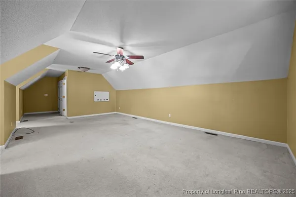 an empty room with a chandelier fan and a large window