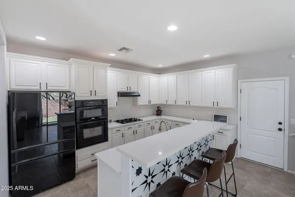a kitchen with stainless steel appliances a refrigerator sink and white cabinets