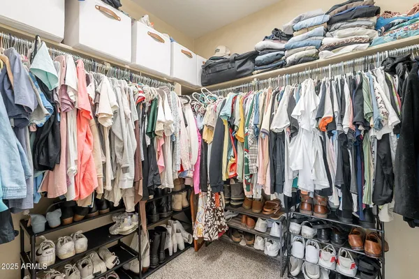 a view of walk in closet with clothes