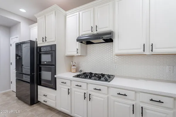 a kitchen with stainless steel appliances granite countertop a refrigerator and a stove