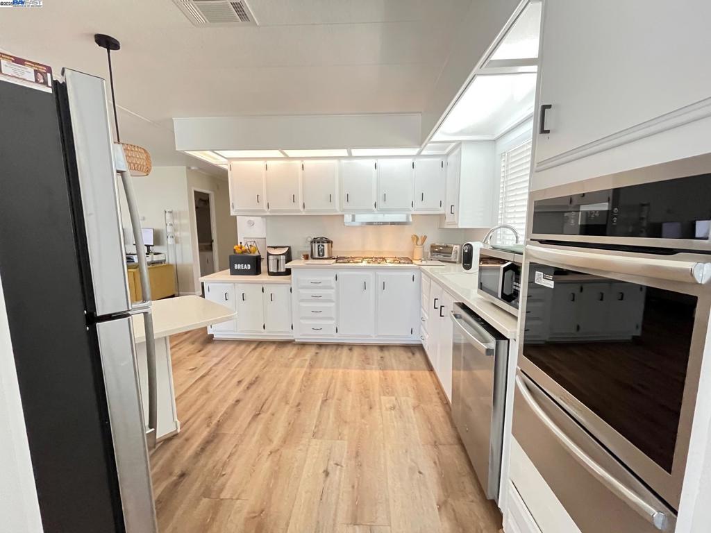 711 Old Canyon Road Fremont, CA 94536 - Photo 12 of 29 a large kitchen with a sink a stove top oven a refrigerator and cabinets