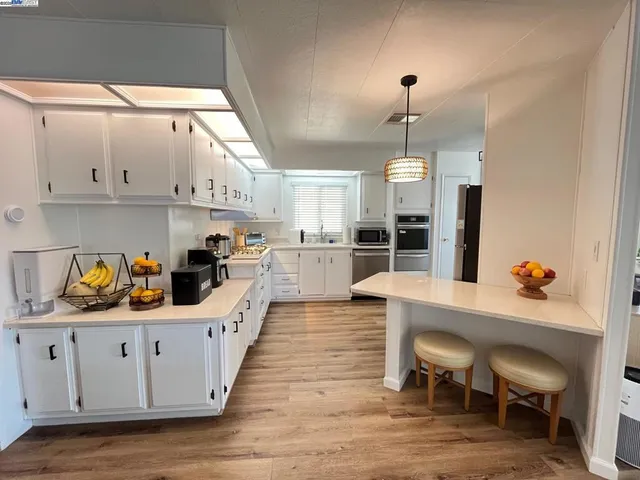 a kitchen with granite countertop a table chairs a sink dishwasher window and cabinets