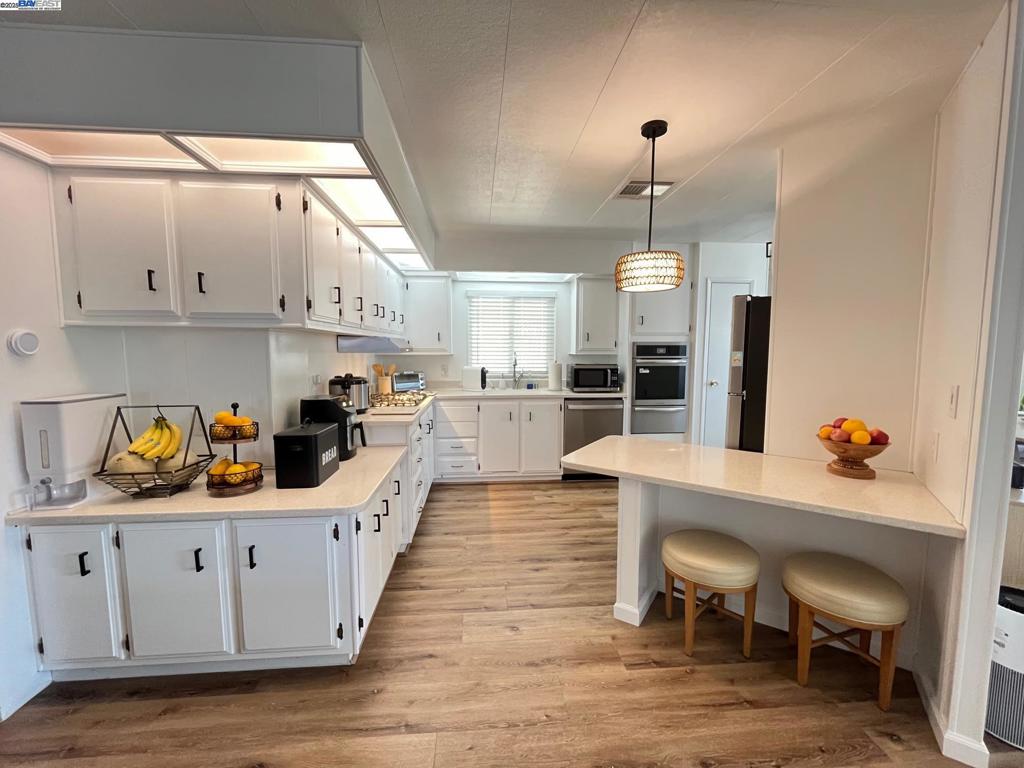 711 Old Canyon Road Fremont, CA 94536 - Photo 6 of 29 a kitchen with granite countertop a table chairs a sink dishwasher window and cabinets