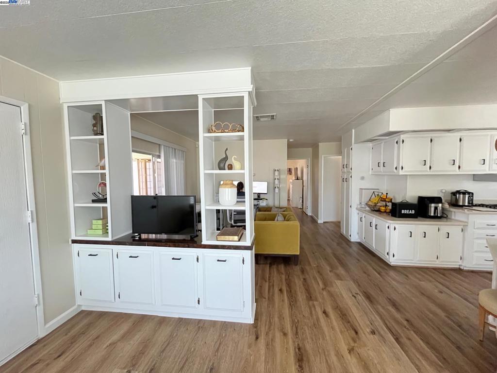 711 Old Canyon Road Fremont, CA 94536 - Photo 8 of 29 a kitchen with stainless steel appliances a stove top oven a refrigerator a sink and cabinets with wooden floor